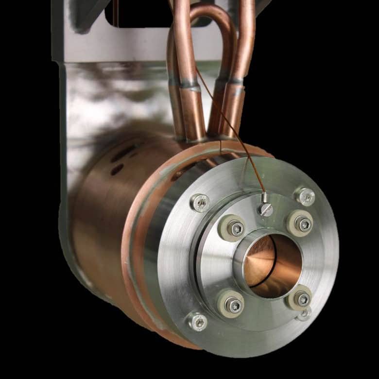 A Faraday cup: a copper and steel cylinder with water-cooling pipes.