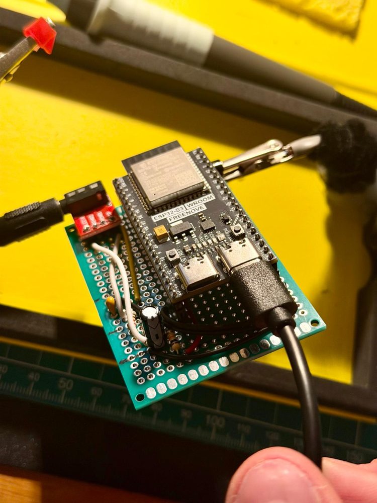 The ESP32-S3 soldered onto green perfboard with the audio jack breakout for the clamp.